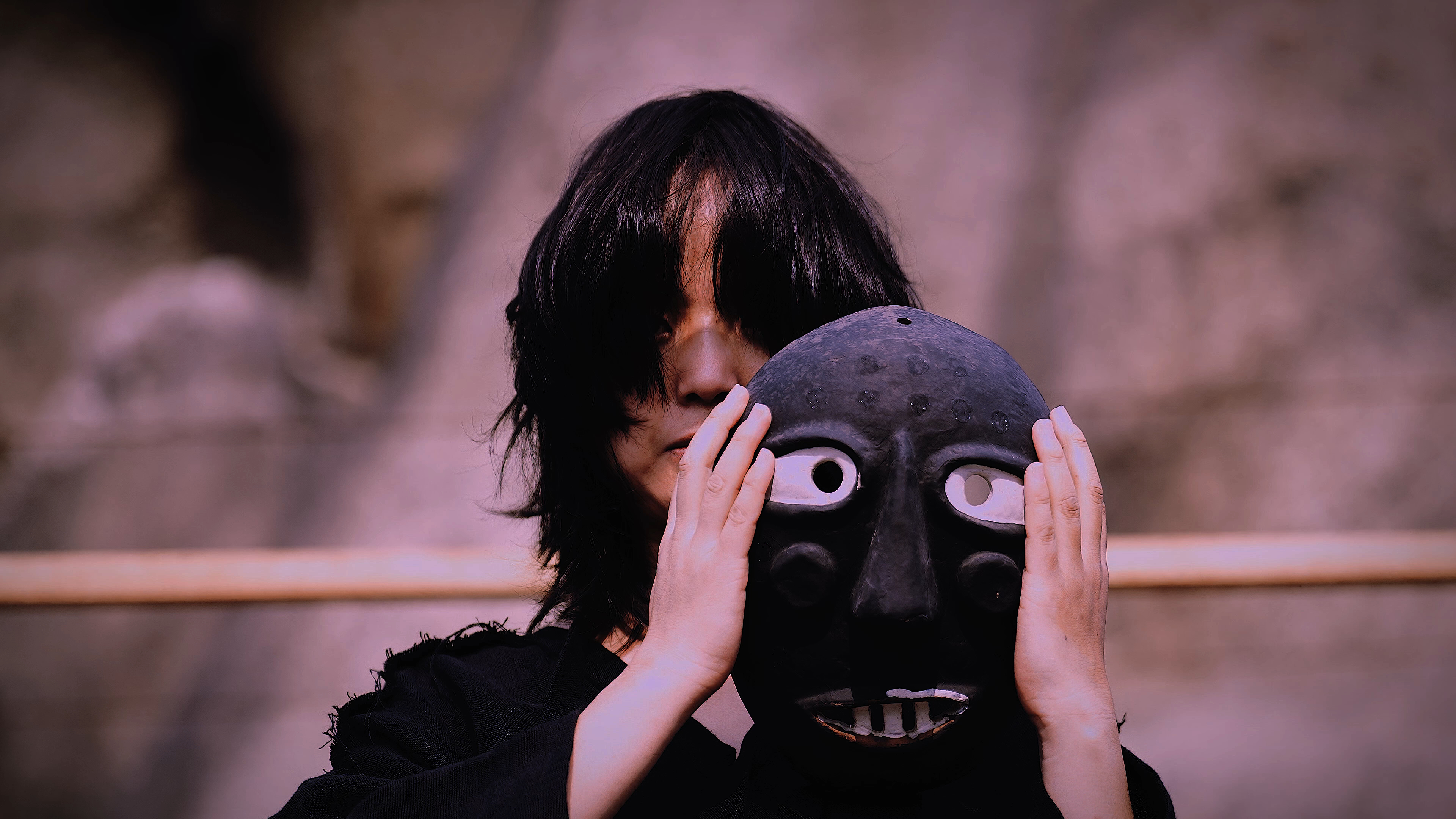 Soojin Pray holding a black ritual mask